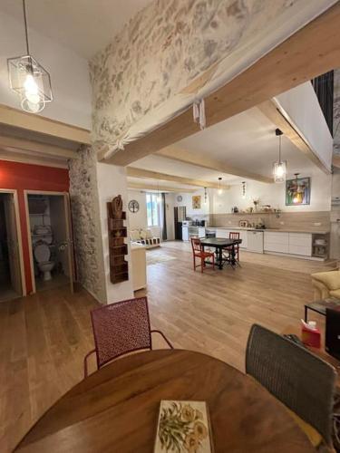 Il comprend un grand salon avec une table et une cuisine. dans l'établissement Maison Charme et Modernité, à Cessenon