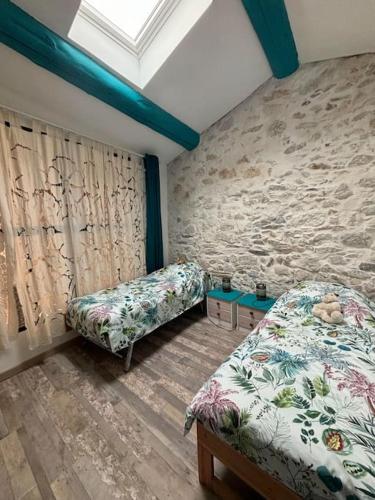 - une chambre avec 2 lits et un mur avec une fenêtre dans l'établissement Maison Charme et Modernité, à Cessenon