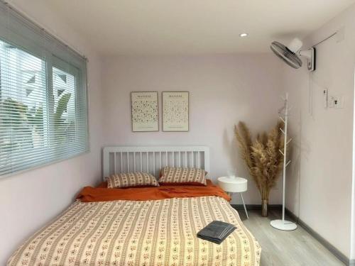 a bedroom with a bed with an orange comforter and a window at Son house Ninh Chữ cách biển 150m to the beach in Ninh Hải