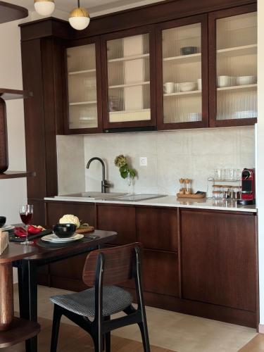 a kitchen with wooden cabinets and a table and chairs at Dream In in Čačak