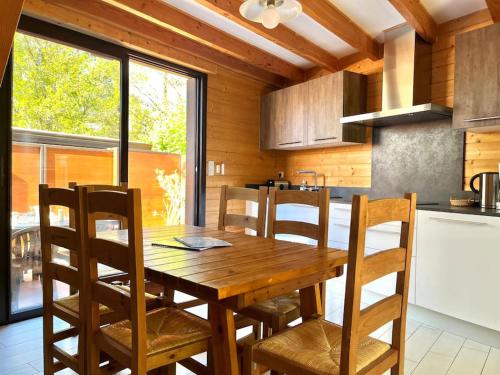 une cuisine avec une table en bois et quelques chaises dans l'établissement Maisonnette climatisée proche de la Dune, à La Teste-de-Buch