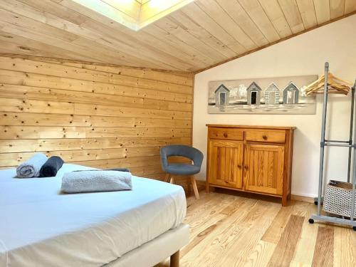 une chambre avec un lit, un bureau et une chaise dans l'établissement Maisonnette climatisée proche de la Dune, à La Teste-de-Buch