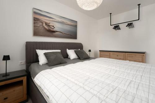 a bedroom with a large bed and a picture on the wall at Eleven in Nova Vas