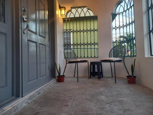 a room with a door and a table and a bench at The Angels Holiday House in Spanish Town