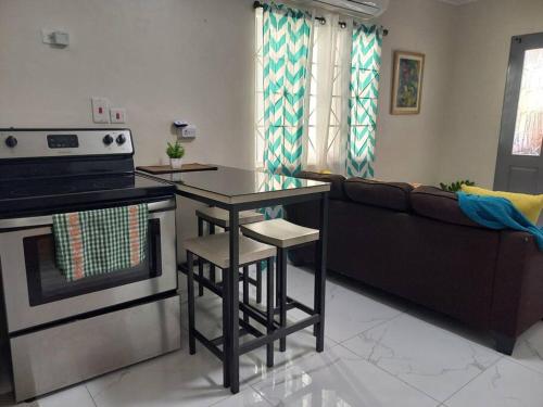 a kitchen with a table and a couch in a living room at The Angels Holiday House in Spanish Town