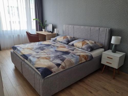 トルナヴァにあるApartment Paulínskaのベッドとランプ付きのナイトスタンドのある寝室