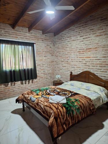 a bedroom with a bed with a tiger blanket at La Casita de Areco in San Antonio de Areco