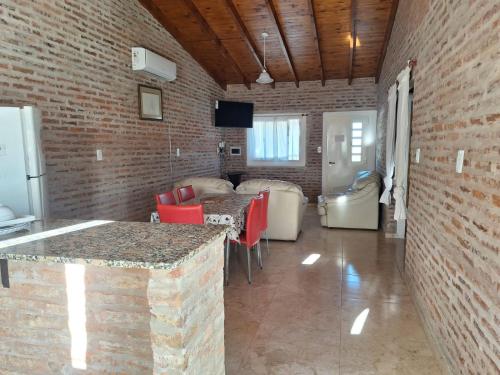 Zimmer mit Ziegelwand, Tisch und Stühlen in der Unterkunft La Casita de Areco in San Antonio de Areco