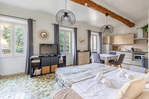 une chambre avec un grand lit et une cuisine dans l'établissement LE FORVILLE lumineux en plein centre, à deux pas du Palais, Croisette et plages, à Cannes