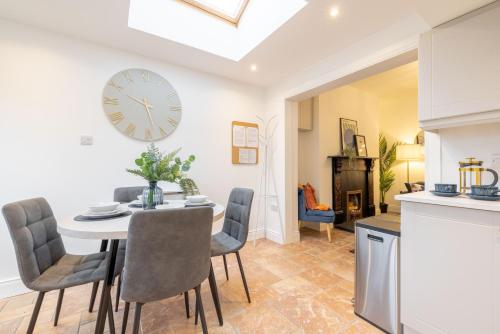 a dining room with a table and chairs and a clock on the wall at Luxury 1 bed Apartment in Portadown