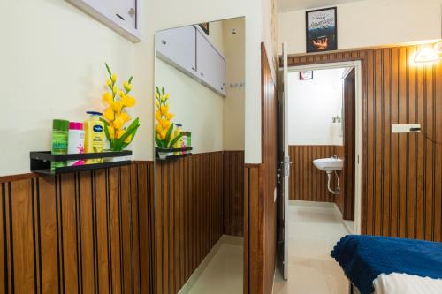 a bathroom with wood paneling and a sink in a room at Mayflower Airport Launge cochin international airport in Nedumbassery