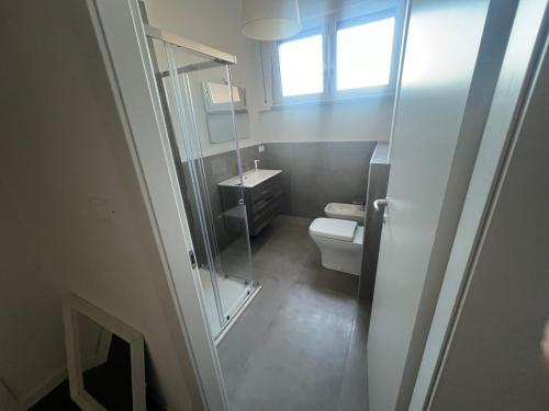 un bagno con un water, un lavandino e una finestra di ManaroomsMasini a Bologna