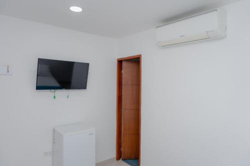 a room with a flat screen tv on a wall at Hotel Aguamarina in Santa Marta