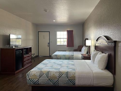 a hotel room with two beds and a flat screen tv at Motel 6-Atoka, OK in Atoka