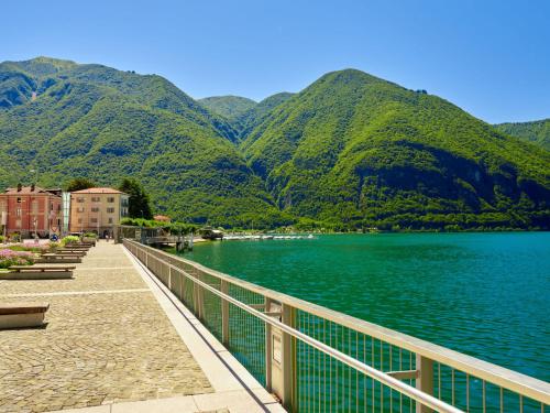 a bridge over a lake with mountains in the background at Holiday Home Marino by Interhome in Cima