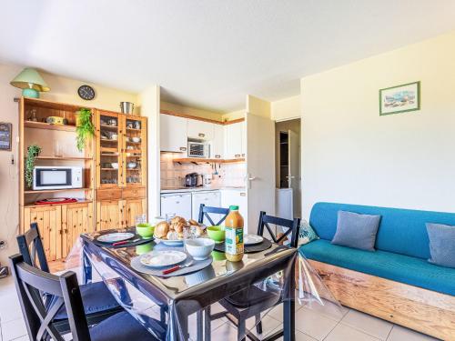 un salon avec une table et un canapé bleu dans l'établissement Apartment Les Marines-16 by Interhome, à La Foux