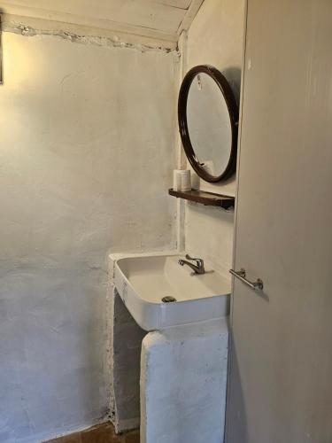 a bathroom with a sink and a mirror on the wall at PANAKLUEA Cottage & Crafts - พนาเกลือ in Ban Kham