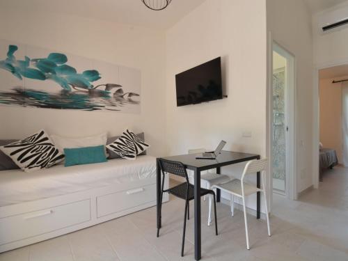 a dining room with a table and a laptop on a couch at Holiday Home Mirto Marino-2 by Interhome in Costa Rei