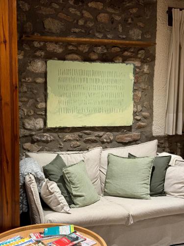a white couch with pillows on a stone wall at Hotel Cal Rei de Talló in Bellver de Cerdanya 
