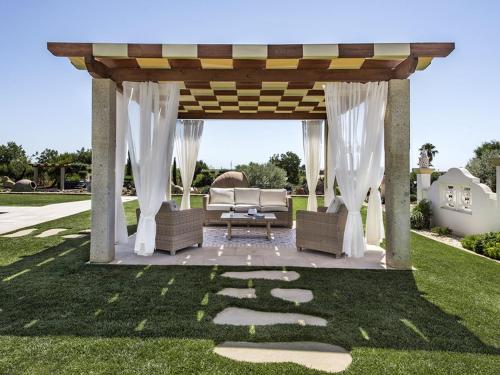a gazebo with a couch on a lawn at Villa Flor de Lis - VIP Properties by Interhome in Paderne