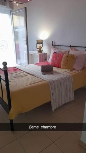 une chambre avec un grand lit avec des oreillers roses dans l'établissement Marseille centre loc, à Marseille