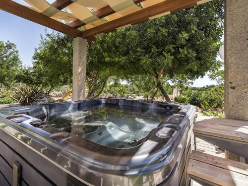 a hot tub on a deck with a pergola at Villa Flor de Lis - VIP Properties by Interhome in Paderne