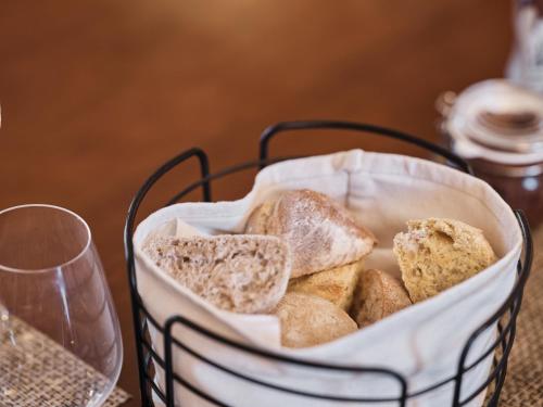 un cesto di pane seduto su un tavolo con un bicchiere di Quinta da Carlota a Torres Vedras