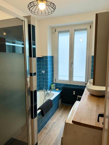 une salle de bain avec une baignoire et un lavabo dans l'établissement Les 6 Cordiers au coeur de ville, à Mulhouse