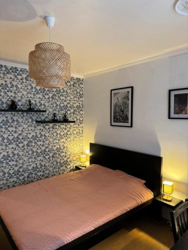 - une chambre avec un lit et un mur recouvert de papier peint dans l'établissement Les 6 Cordiers au coeur de ville, à Mulhouse