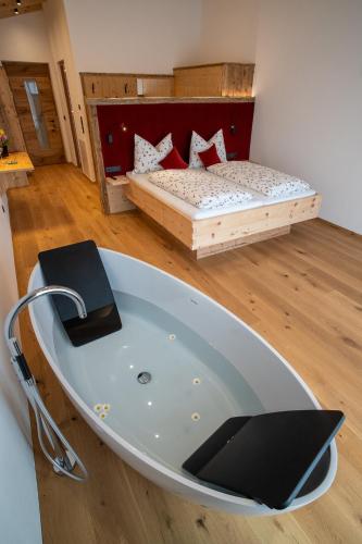 a bath tub in the middle of a room with a bed at Lanzenschuster in San Genesio Atesino
