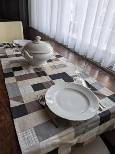 a table with a checkered table cloth with a plate and wine glass at Gemütliche Wohnung im Retrostil in Nattheim