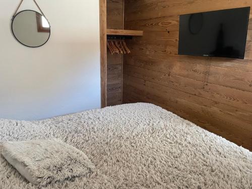 une chambre avec un lit et une télévision à écran plat dans l'établissement Appartement 6 pers les Orres 1800 - Piscine chauffée Sauna, aux Orres