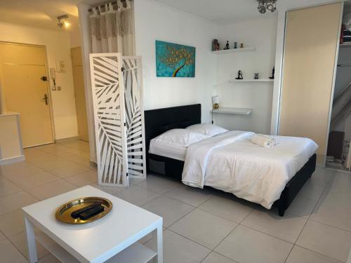 - une chambre dotée d'un lit blanc, d'une table et d'un lit sidx sidx dans l'établissement B075-Studio agréable centre Cannes, à Cannes