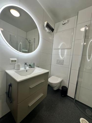 トロムソにあるSentral studioleilighetの洗面台、鏡、トイレ付きのバスルーム