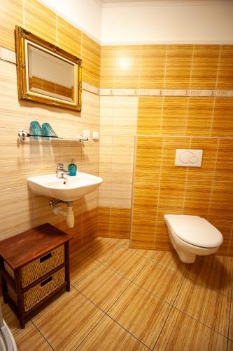 a bathroom with a sink and a toilet and a mirror at Penzion Anebel in Luhačovice