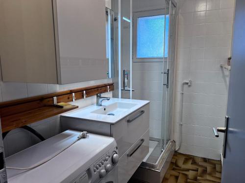 La salle de bains blanche est pourvue d'un évier et d'une cuisinière. dans l'établissement Appartement cosy, proche pistes et centre, 3 pièces, 6 pers, cheminée, balcon, parking - FR-1-437-53, à La Clusaz