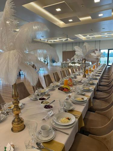 a long table with plates of food and white feathers at MDS Bonikowo in Bonikowo