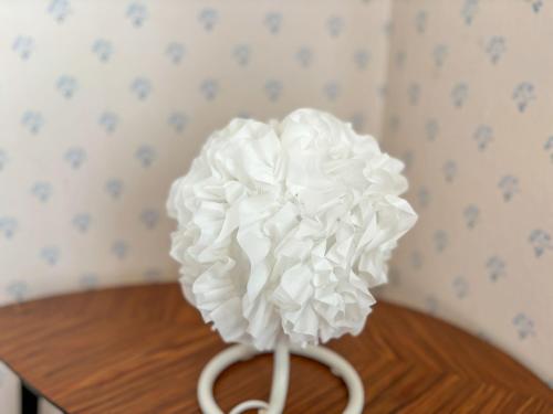 a white flower on top of a wooden table at Seegut Hovmantorp in Hovmantorp