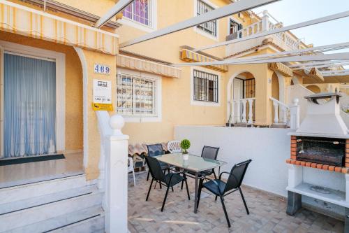 a patio with a table and chairs and a fireplace at Duplex En Gran Alacant in Puerto Marino