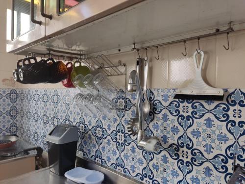 a kitchen with blue and white tiles on the wall at Colonial Praiano in Guarapari