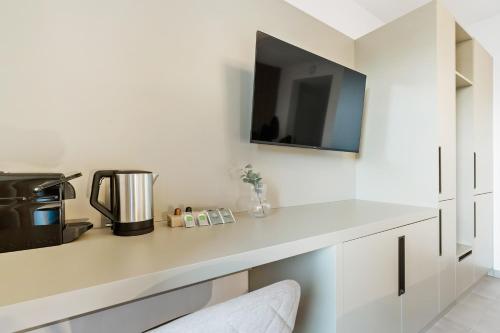 a kitchen with a white counter with a tv on the wall at Comfort & Style in Vibrant Luxembourg Coliving in Luxembourg