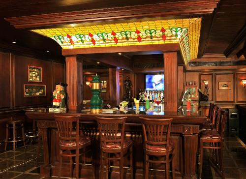 a bar with wooden stools and a counter in a restaurant at Park Plaza Faridabad in Faridabad