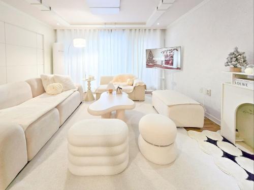 a white living room with a white couch and chairs at Yeon Stay in Seoul
