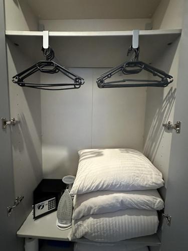 Cette petite chambre comprend un lit et deux cintres. dans l'établissement Studio Proche Tour Eiffel, à Paris