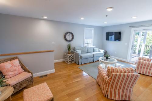 a living room with a couch and a clock on the wall at The Newport Lofts - 617 Thames Street in Newport