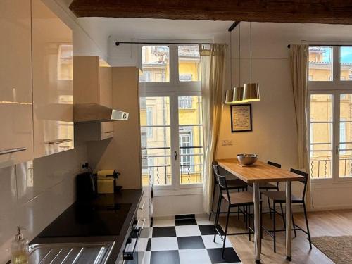 une cuisine avec une table et quelques chaises dans une pièce dans l'établissement Le Prêcheur, à Aix-en-Provence