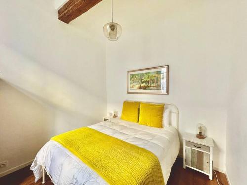 une chambre avec un lit avec des oreillers jaunes dans l'établissement Le Havre Aixois, à Aix-en-Provence