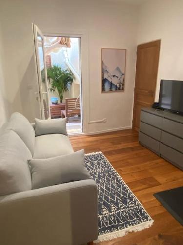 un salon avec un canapé et une télévision dans l'établissement Le Havre Aixois, à Aix-en-Provence