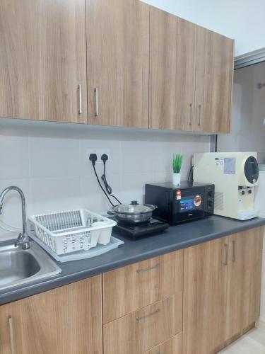 a kitchen counter with a microwave and a sink at KLIA Travel Homestay - 3R 2B - WIFI & NETFLIX in Sepang