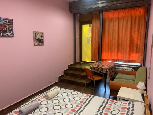 ソフィアにあるライク ホーム ゲスト ルームズのベッド2台とテーブルと窓のある部屋